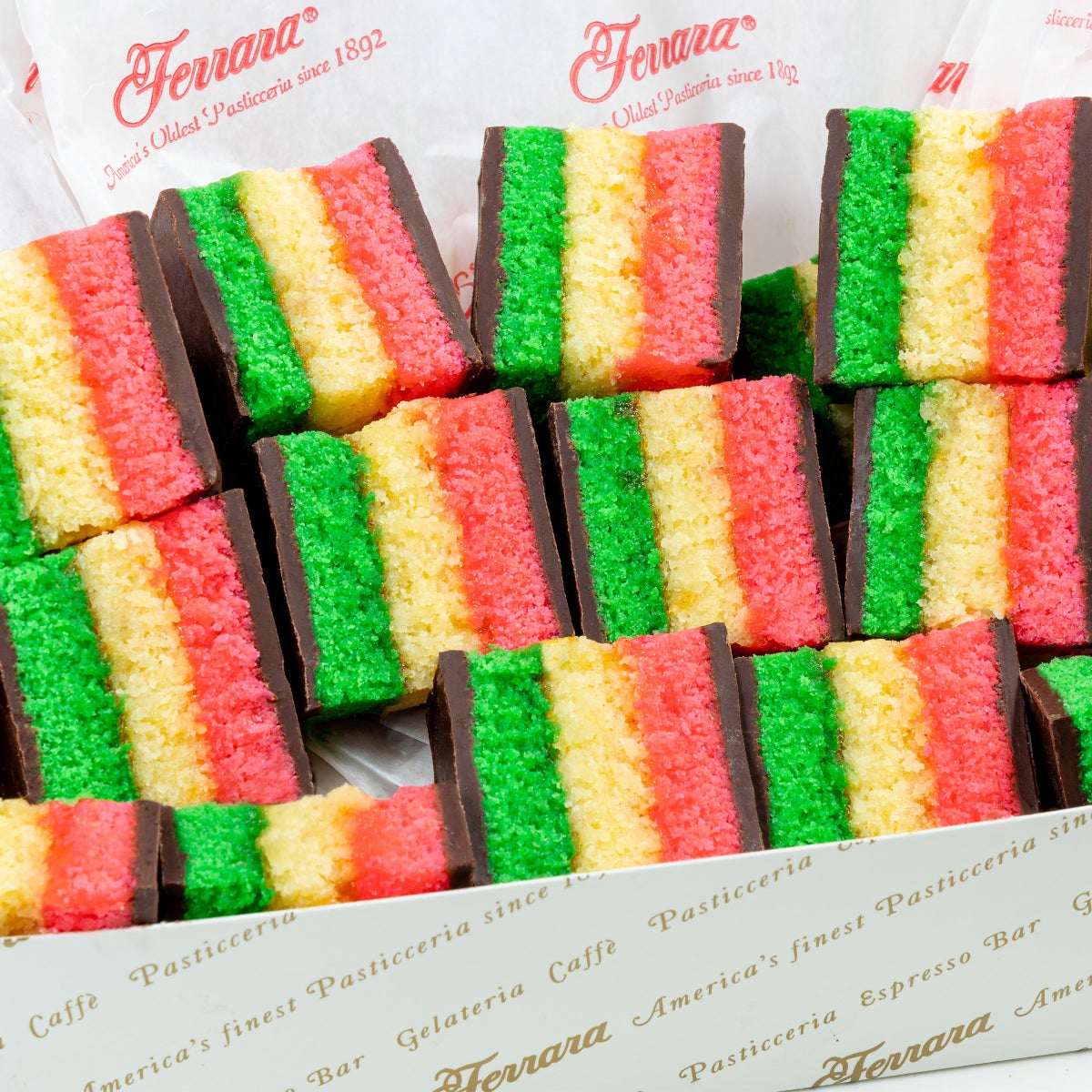 Small-batch bakery rainbow cookies stacked on display