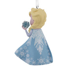 Elsa in a blue gown holding an ice snowflake