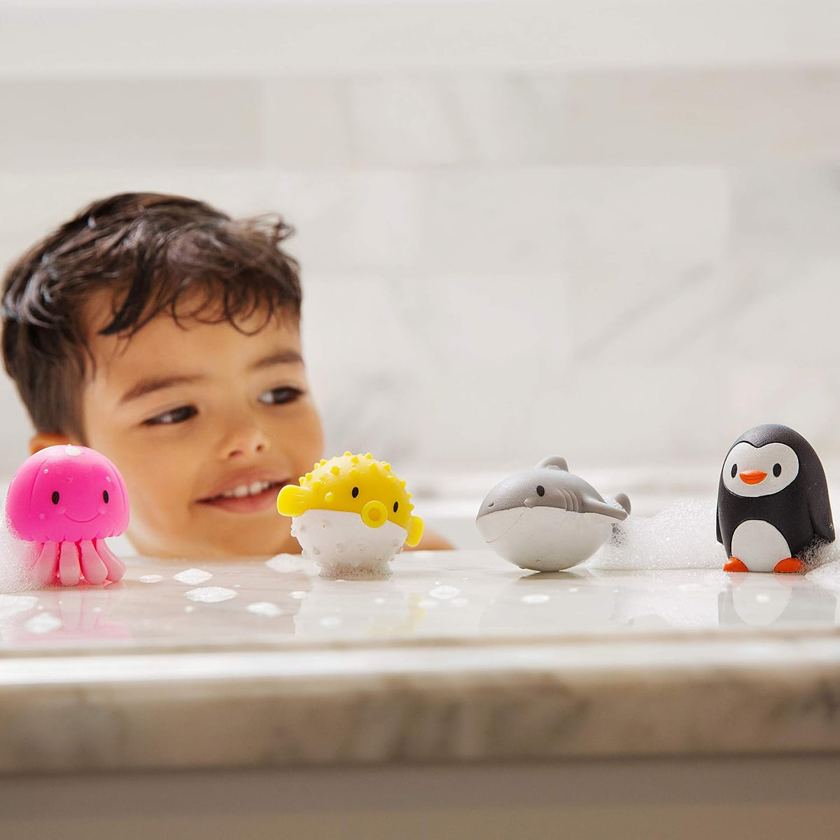 Munchkin baby bath toys in clear storage canister