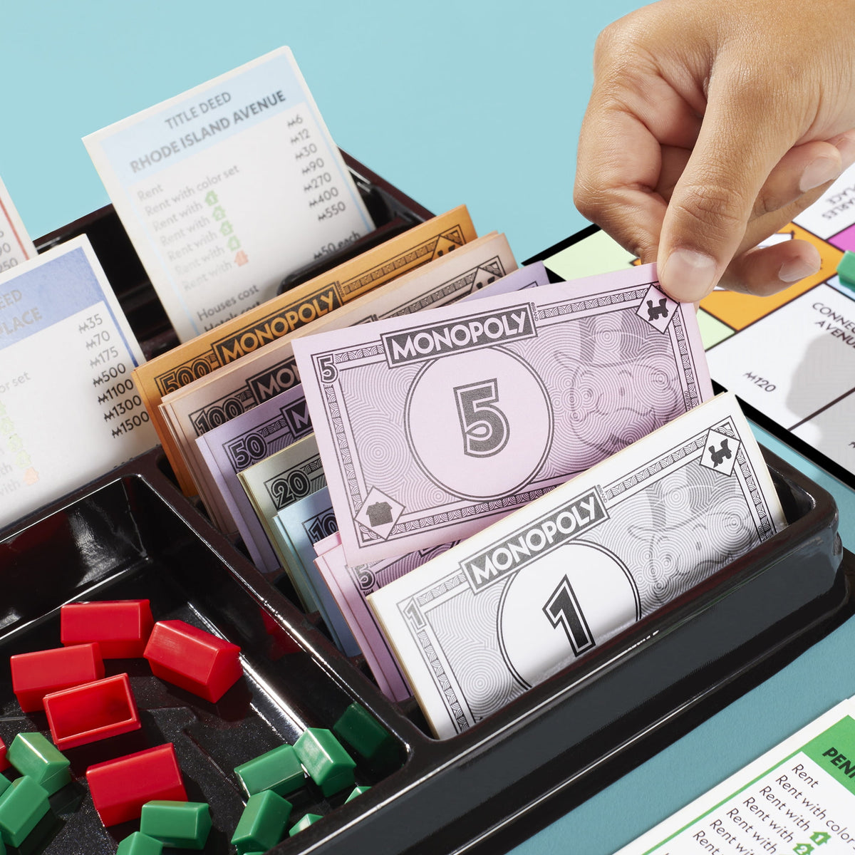 Monopoly board game with storage tray